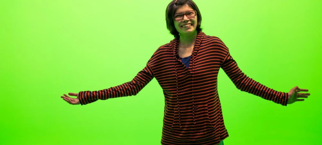 female student in front of green screen