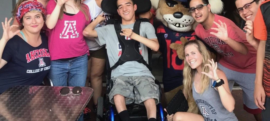 groups of students at pep rally posing with wildcat hand symbol