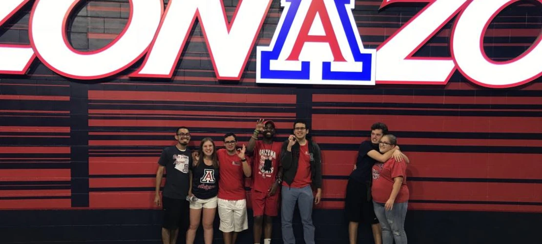 group of students standing in front of ZonaZoo sign