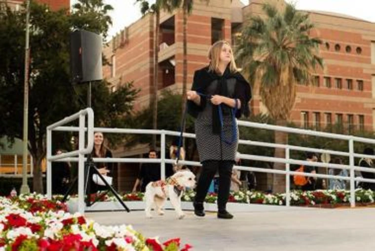 young lady walking a dog on a leash on stage